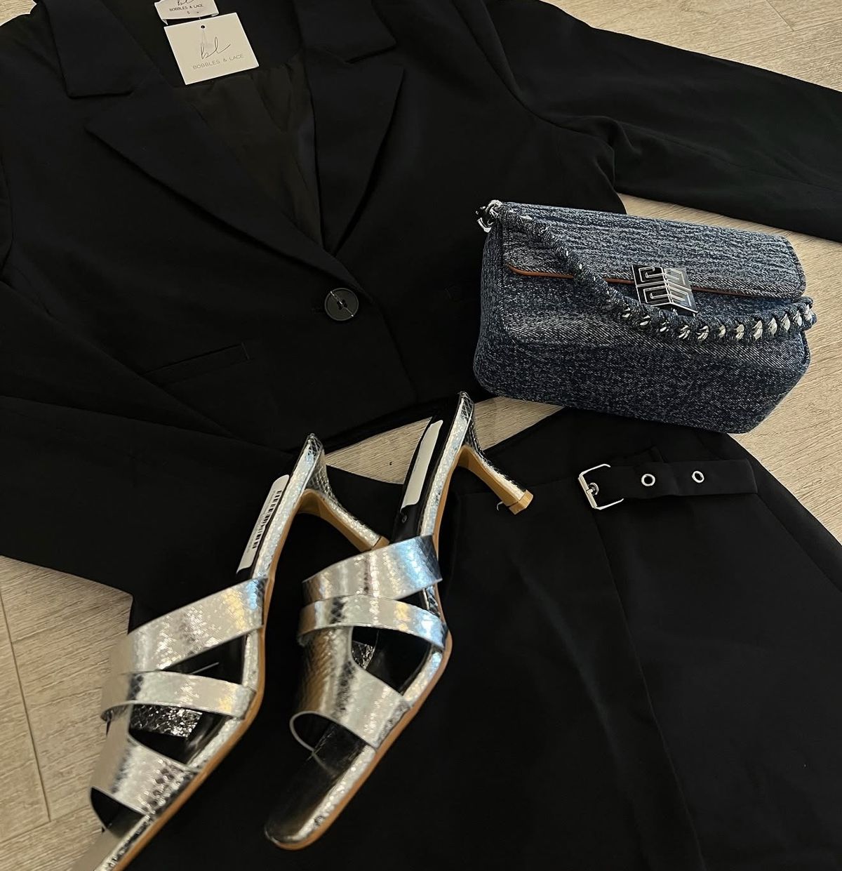 Styled flat lay with blazer, bag and metallic sandals