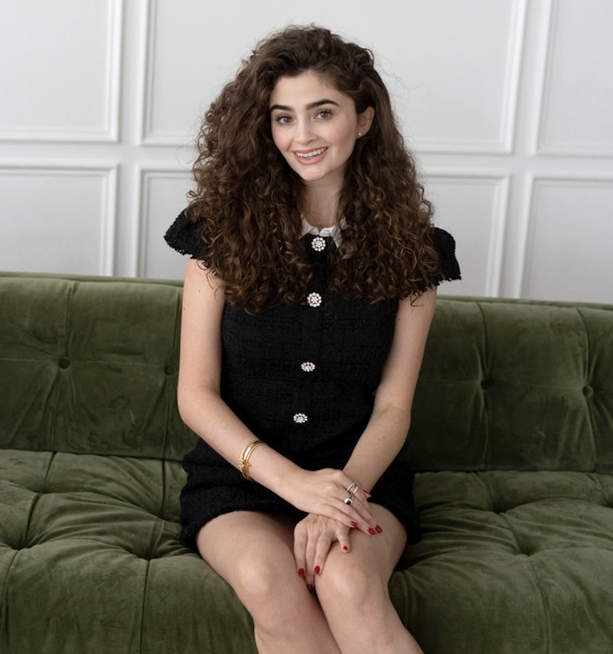 Lila Albright seated on a green velvet sofa